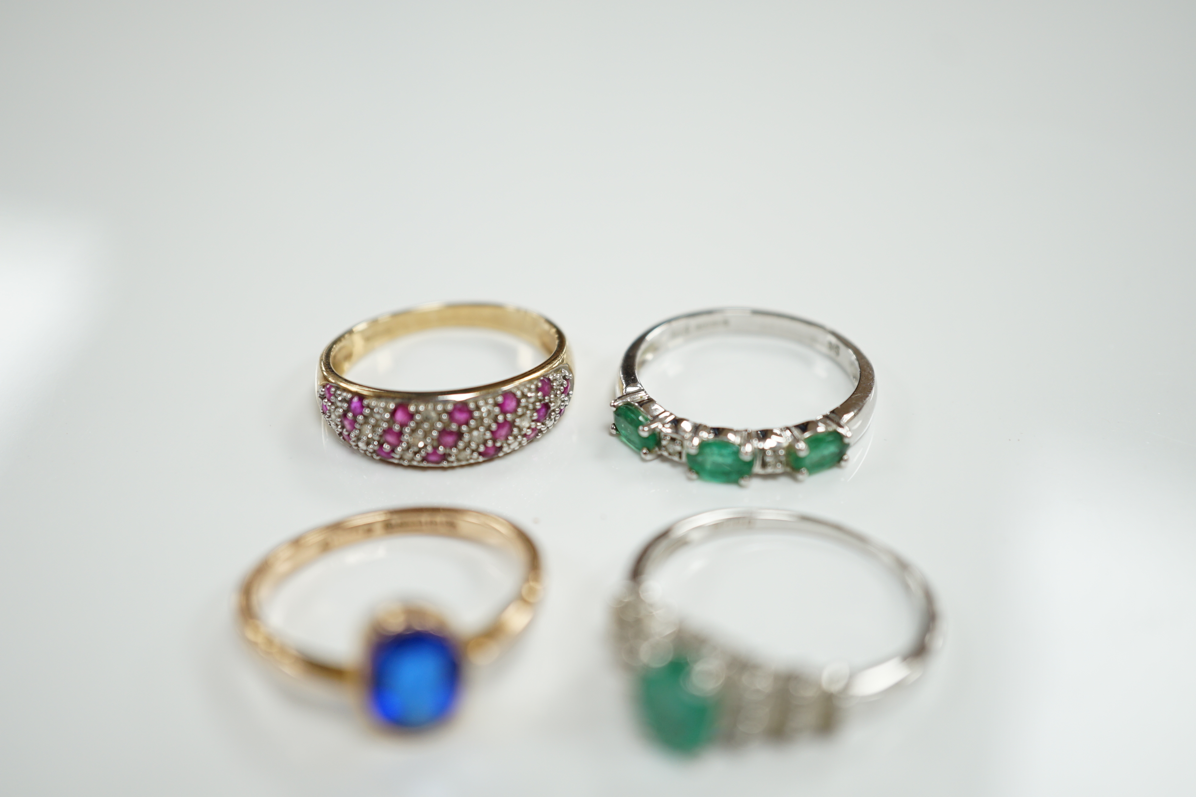 Three assorted modern 9ct gold and gem set rings including emerald and diamond chip set half hoop, size N, gross weight 6.8 grams and a modern14ct white gold and single stone emerald set dress ring, with baguette cut dia
